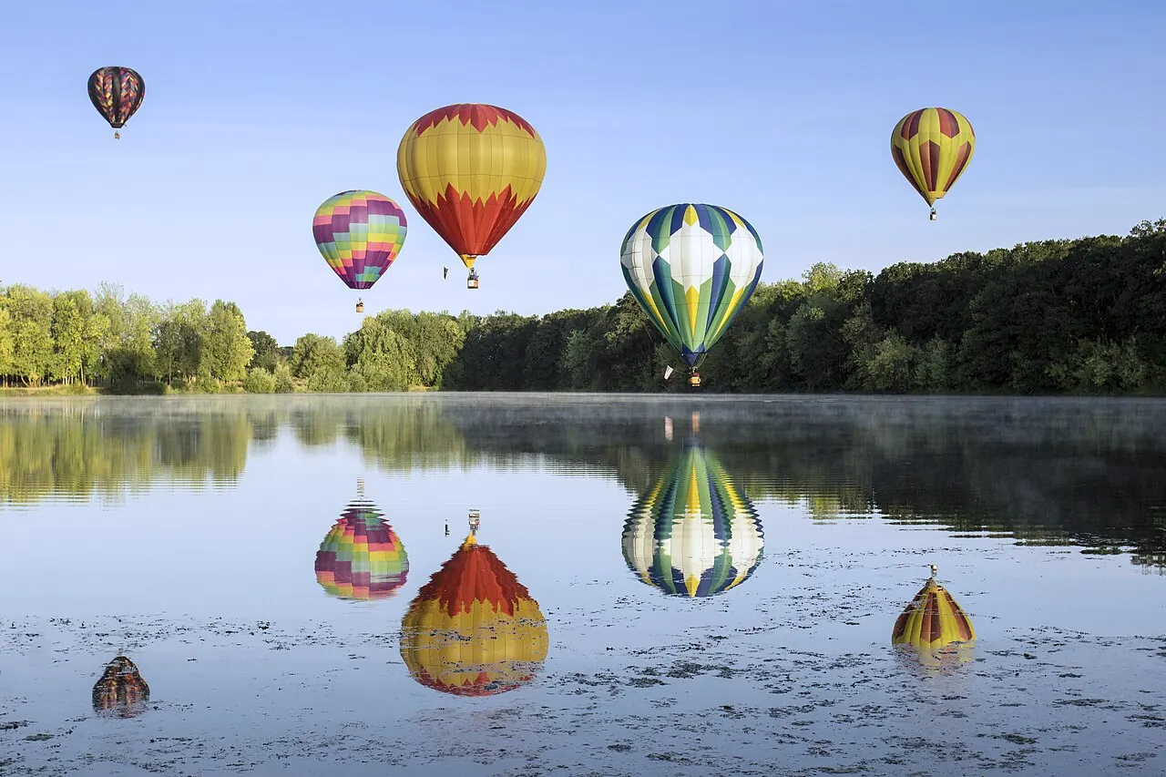 Hot air balloons reflected in a lake at the Northwest Art and Air Festival in Albany, Oregon