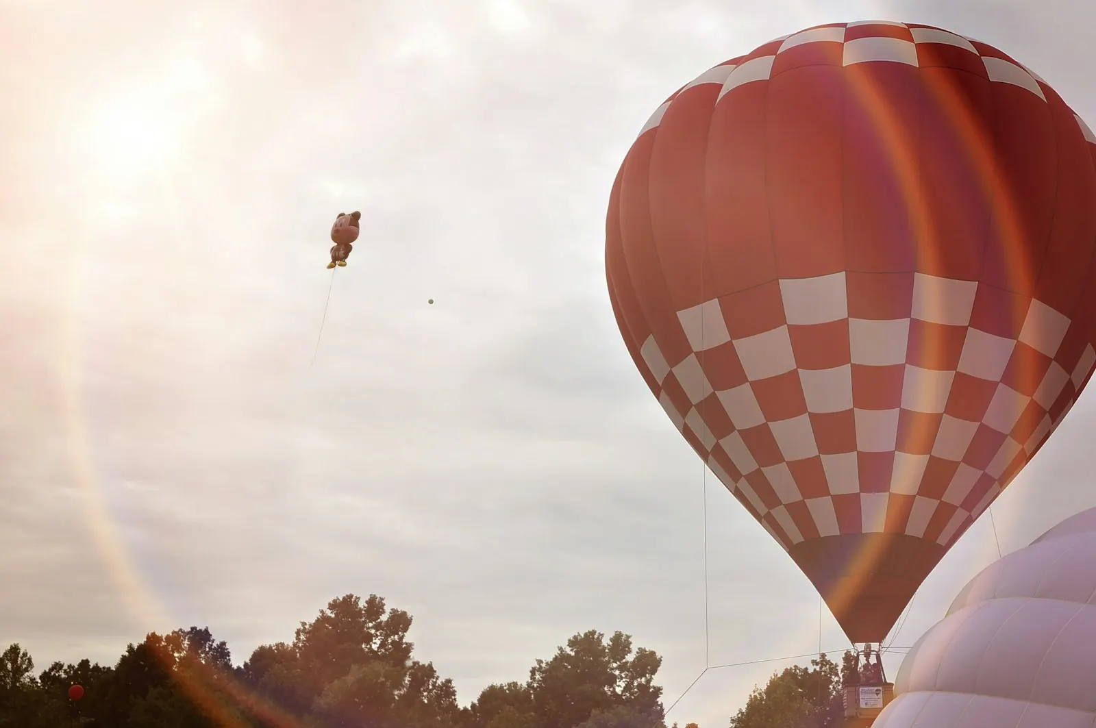 A hot air balloon lit by the sun over Atlanta